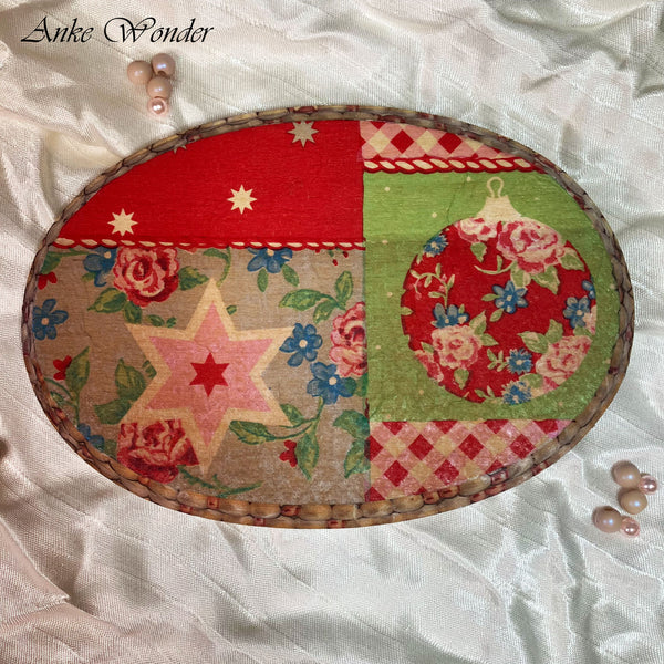 Handmade wooden wall decor with a vintage Christmas design, featuring a floral ornament, star pattern, and festive patchwork in red, green, and beige tones. The oval plaque is bordered with a handwoven edge and set against a soft fabric backdrop with pearl embellishments.