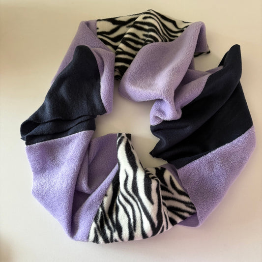 Purple and blue infinity scarf the other zebra print, on a light beige background.