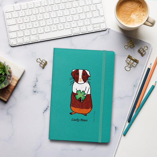 Lucky Paws Guinea Pig Notebook on a desk with a coffee mug, pencil, and keyboard, ideal for capturing daily reflections and inspirations.