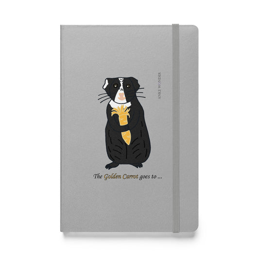Front view of "The Golden Carrot goes to..." Guinea Pig Notebook featuring a proud guinea pig with a golden carrot on a clean white background designed by Anke Wonder.