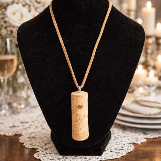 Tree trunk necklace on a black velvet stand with a blurred background of a dining setting.