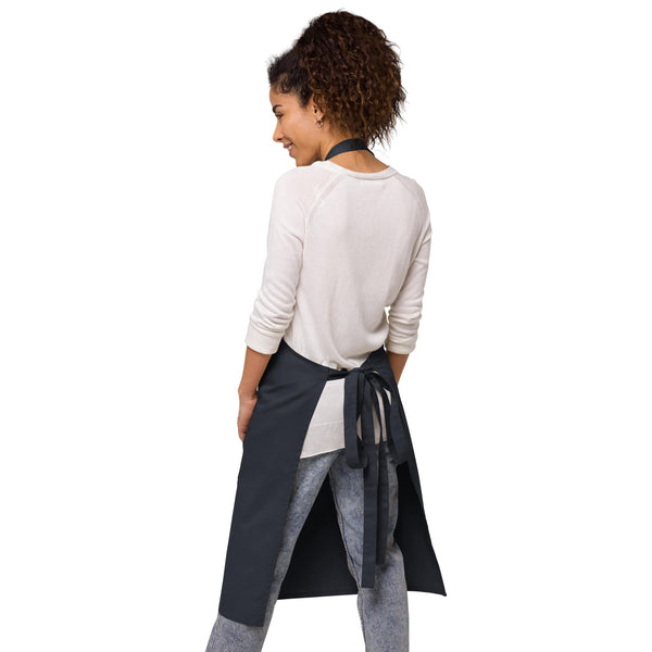 The back view of the navy apron, highlighting adjustable straps and a neat waist tie, designed by Anke Wonder.
