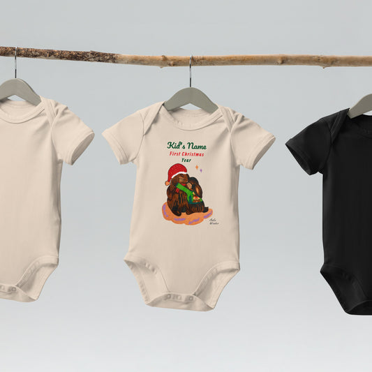 Beige baby onesies on hangers with a Christmas-themed rabbit design and text.
