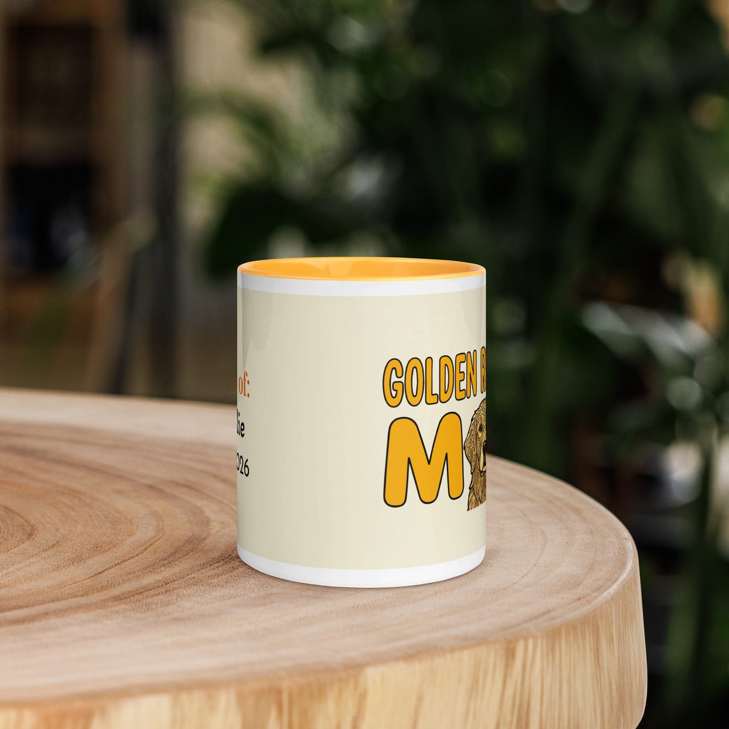 Mug with 'Golden Retriever Mom' text on a wooden surface with a blurred green background