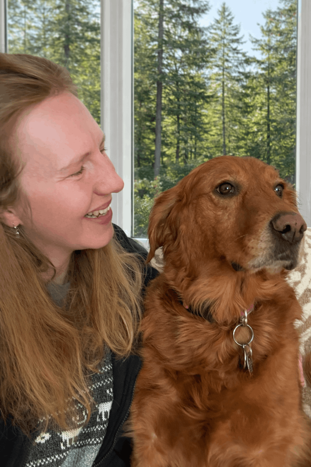 Anke Wonder and dog sitting together with a view of trees outside a window