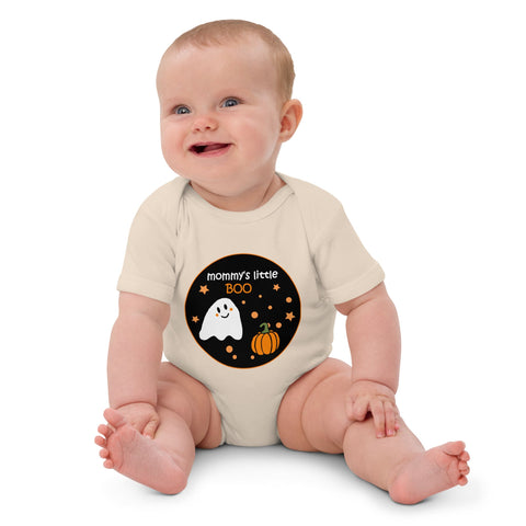 Baby girl wearing the organic cotton baby bodysuit in natural color, featuring a cute ghost and pumpkin design with "Mommy's Little BOO" text. Designed by Anke Wonder for Halloween.