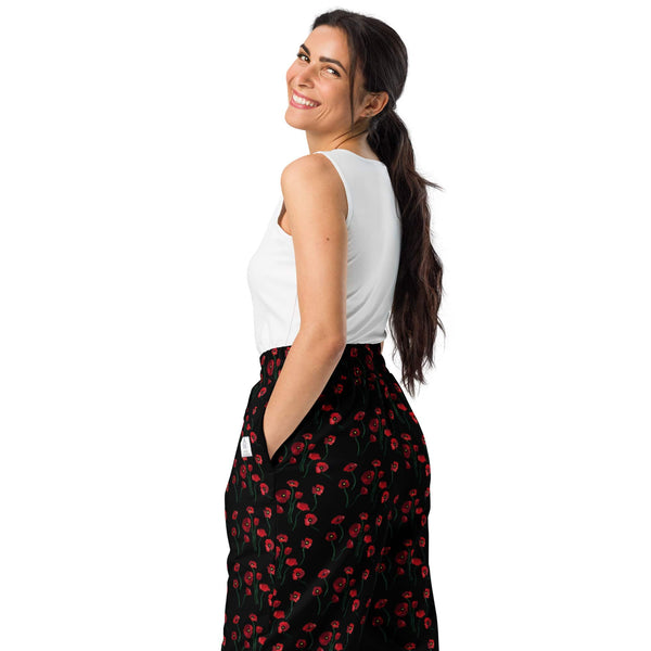 Back view of women's wide-leg joggers with red poppy flower print, displaying the elastic waistband and flowy cut from behind.