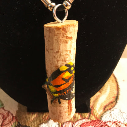 Wood pendant with a painted butterfly design on a black background