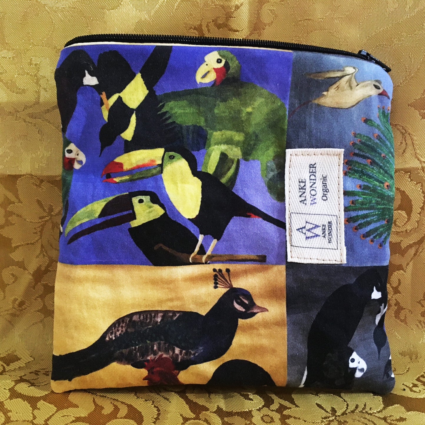 Fabric pouch with bird collage design on a gold patterned background