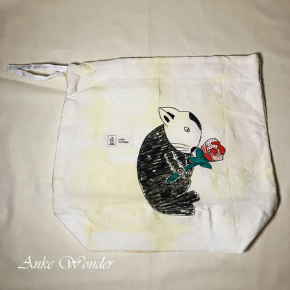 Tote bag with a cartoon rabbit design holding a rose on a beige background