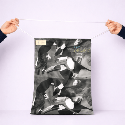 Person holding a fabric with black and whit tropical abstract bird design and 'I am Organic' text.