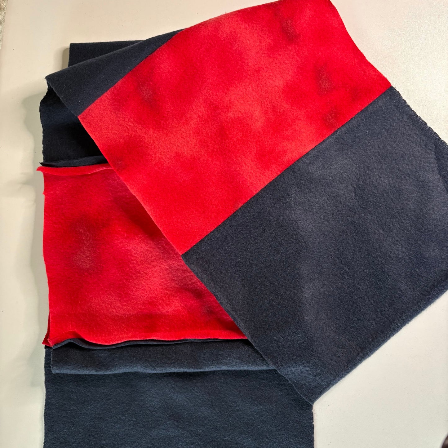 Red and blue womens scarf on a beige surface