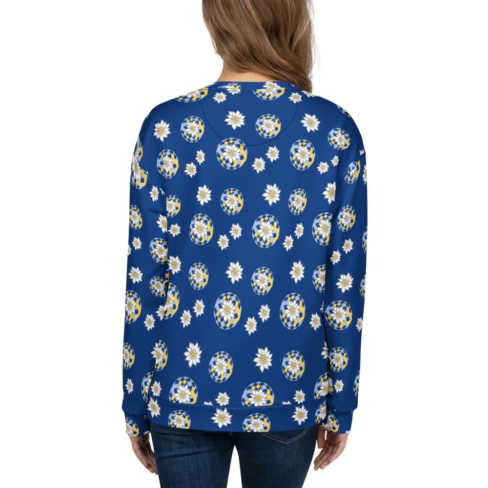 Back view of woman wearing a blue sweatshirt with white floral pattern of Alpine Edelweiss on a white background