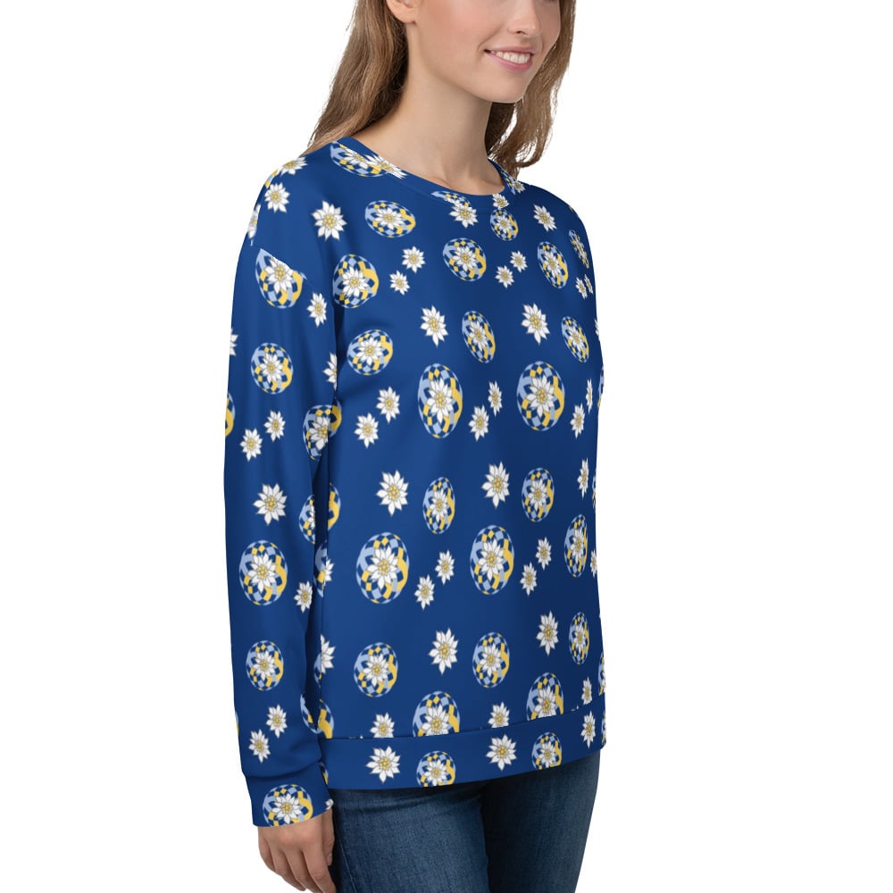 Side view of woman wearing a blue floral patterned Edelweiss sweatshirt on a white background