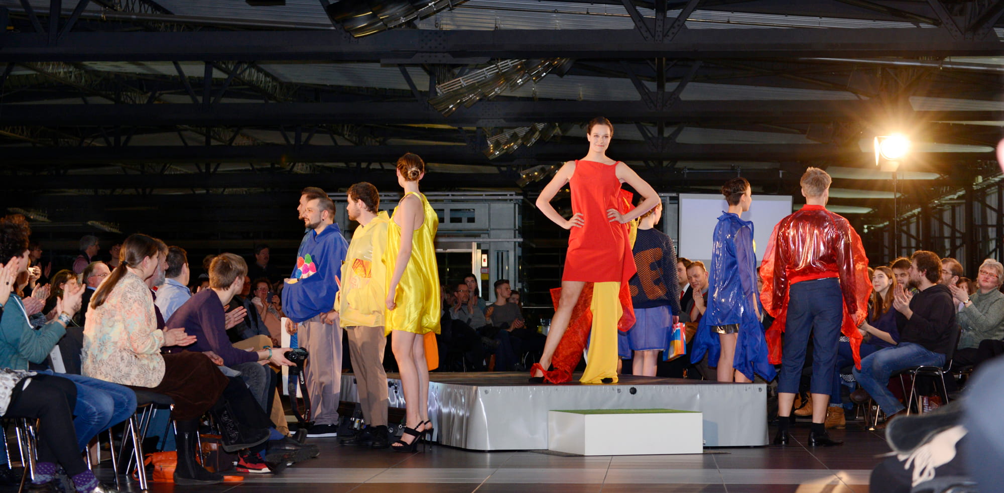 Fashion show with models on a runway in front of an audience