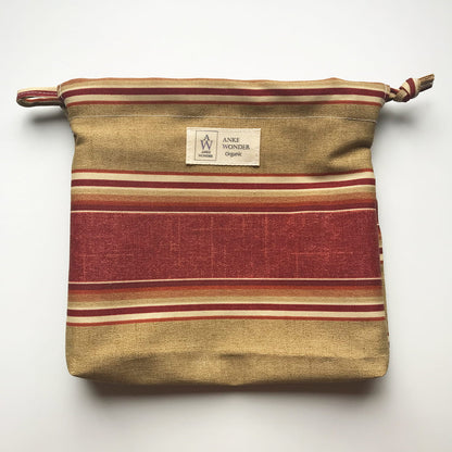 Striped fabric pouch with a visible brand label on a white background