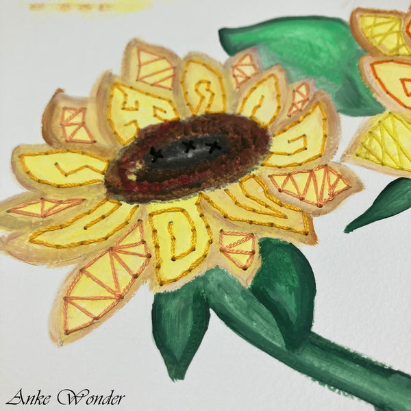 Close-up view of a hand-embroidered sunflower with bright yellow and orange petals, unique embroidery details, and a deep textured center, crafted by Anke Wonder.