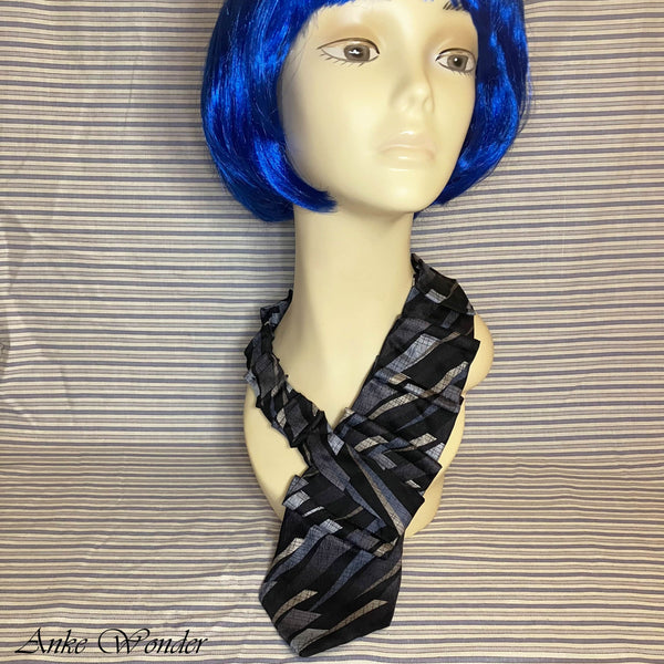 Full front view of the handmade blue and silver geometric silk necktie displayed on a mannequin, showcasing its overall length and unique design.