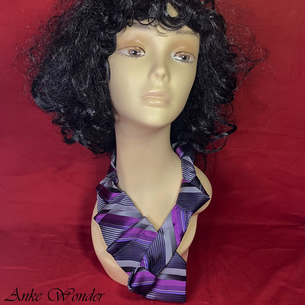 Purple women's necktie with geometric patterns and pyramid pleats displayed on a mannequin, showcasing the eco-friendly design made from upcycled silk.