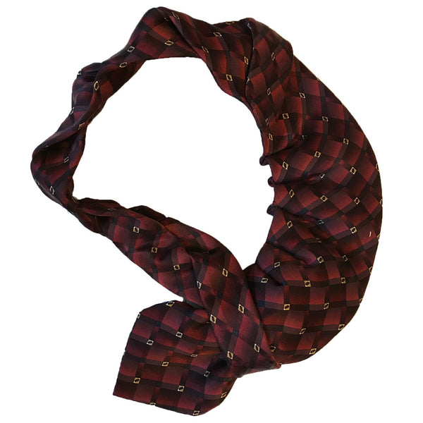 Red and gold plaid silk necktie displayed flat on a table, showcasing its intricate pattern and design.