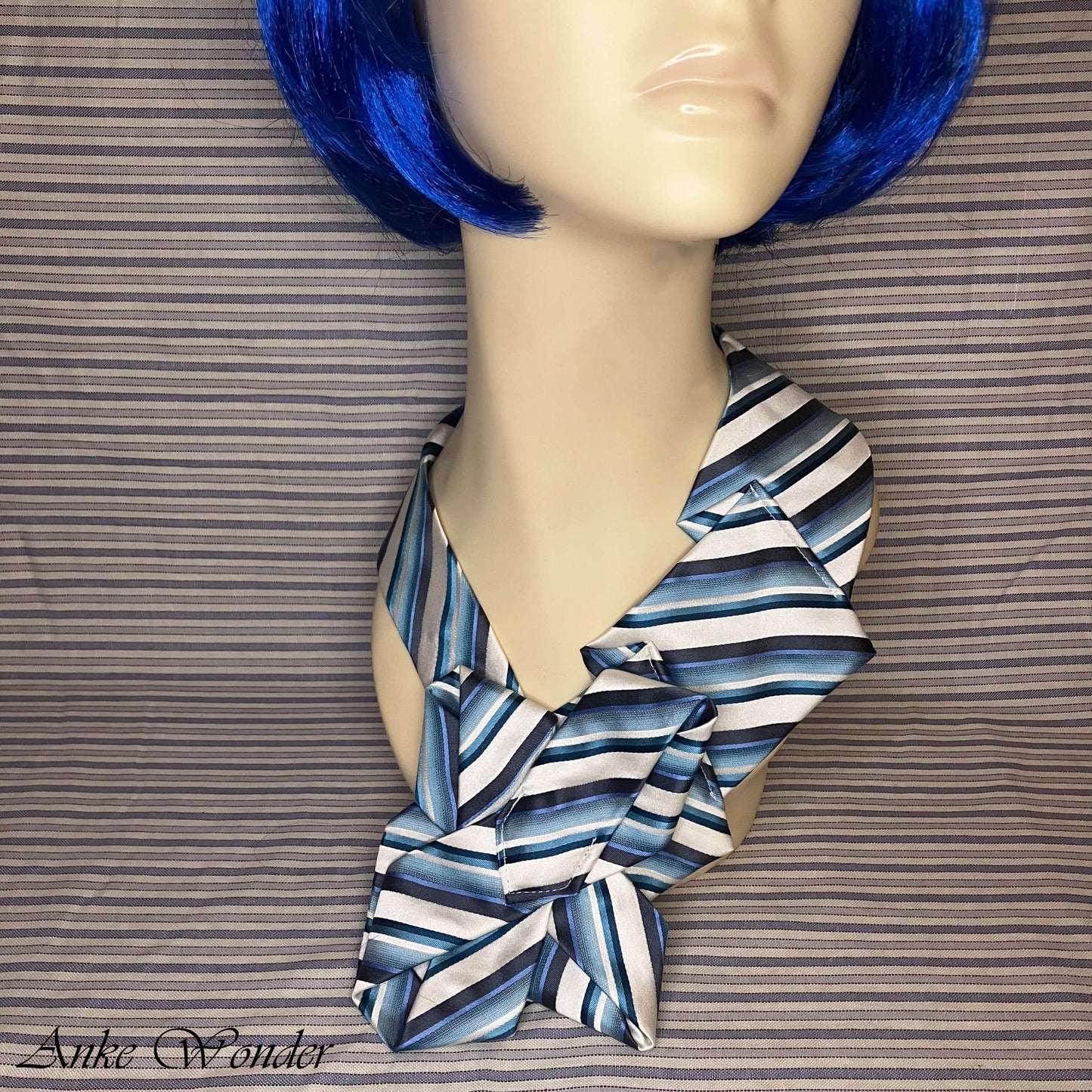 Close-up of necktie on mannequin - detailed view of blue and white striped pattern.
