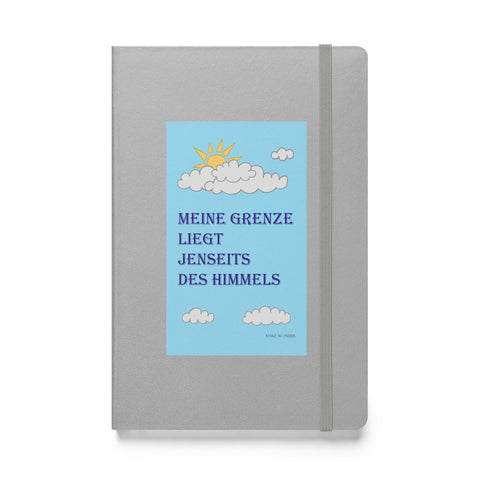 ront cover of hardcover notebook featuring the phrase "Meine Grenze liegt jenseits des Himmels" in blue lettering, displayed against a white background.