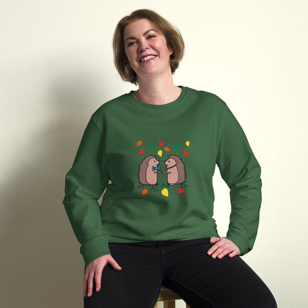 Plus-size model wearing Hedgehog Hugs Organic Cotton Women Sweatshirt in green, featuring two hedgehogs holding hands surrounded by colorful leaves, designed by Anke Wonder.