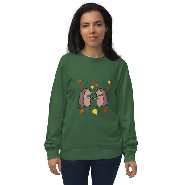 Model wearing Hedgehog Hugs Organic Cotton Women Sweatshirt in green, featuring two hedgehogs holding hands surrounded by colorful leaves, designed by Anke Wonder.