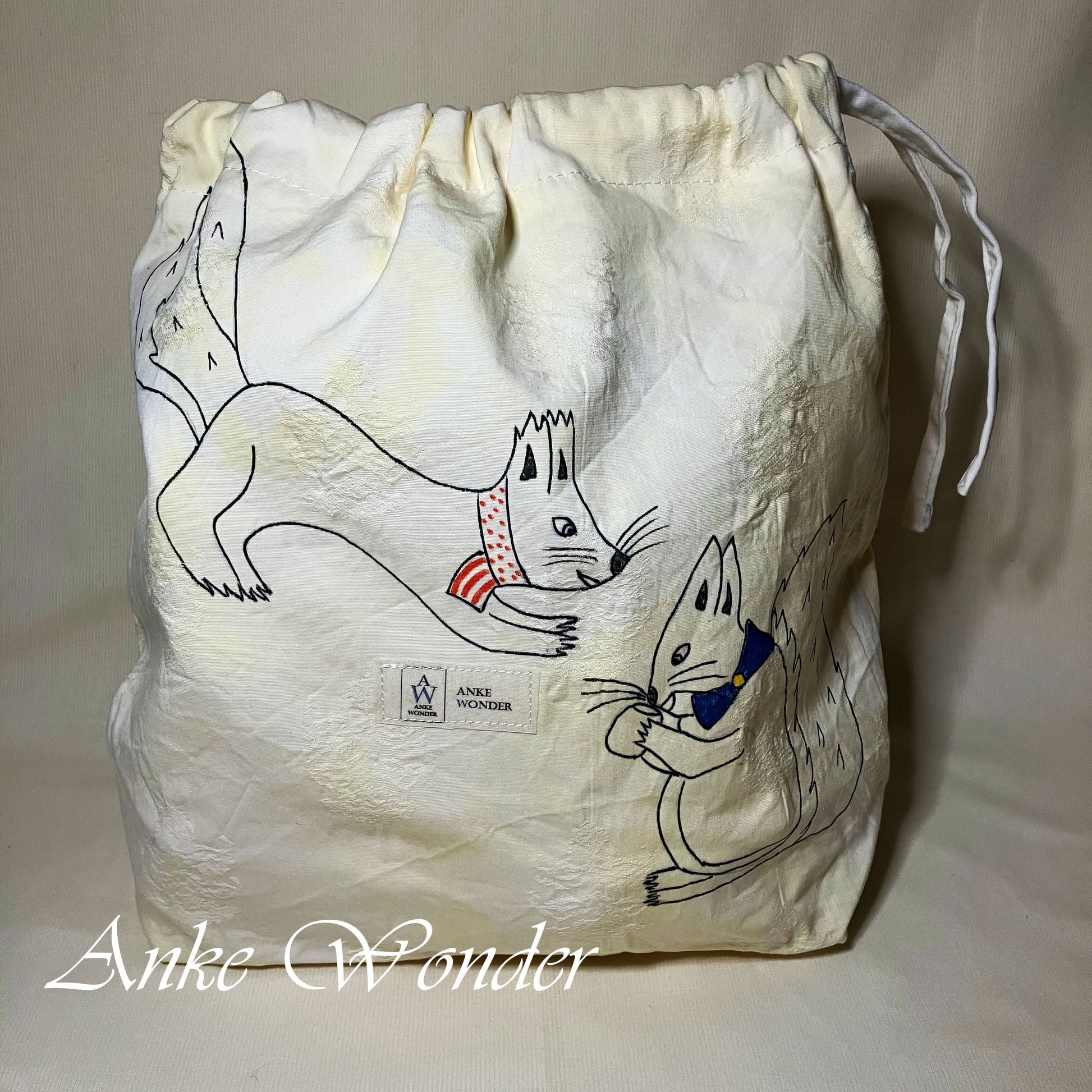 Drawstring bag with cartoon squirrel design and 'Anke Wonder' branding on a beige background