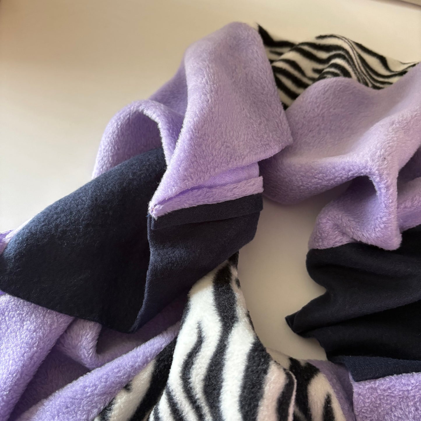 Purple, Navy, Zebra Pattern Infinity Scarf close-up on a light surface.