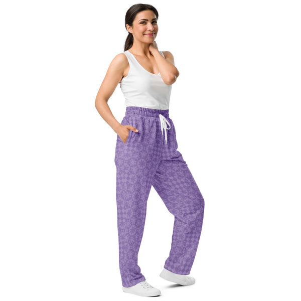 A woman wearing lavender wide-leg joggers with a geometric pattern - shown from the side with view of the side pocket.