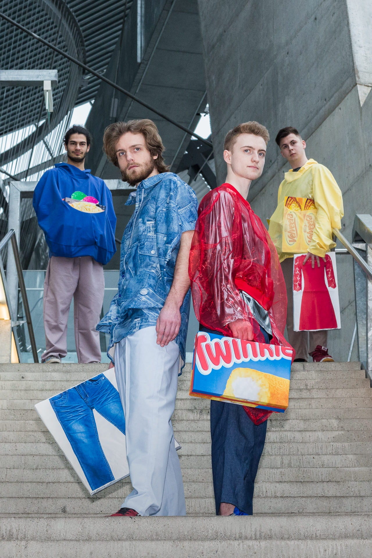 Four individuals standing on a staircase wearing colorful outfits with visible branding.