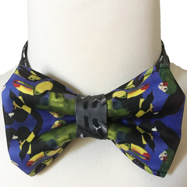 Men's organic cotton bow tie with a vibrant colorful bird print, displayed on a mannequin, front view.