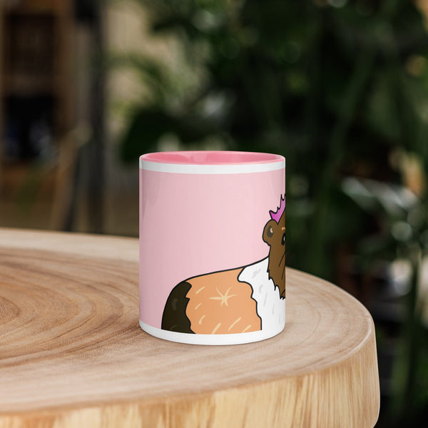 Front view of pink ceramic mug featuring a black and white guinea pig wearing a crown, adding elegance and charm to your drinkware.