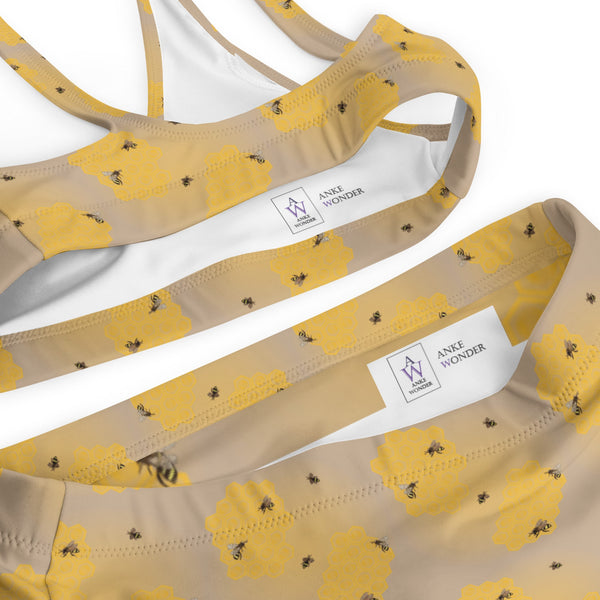 A close-up of the recycled high-waisted bikini featuring a honeycomb bee design and a subtle logo detail.