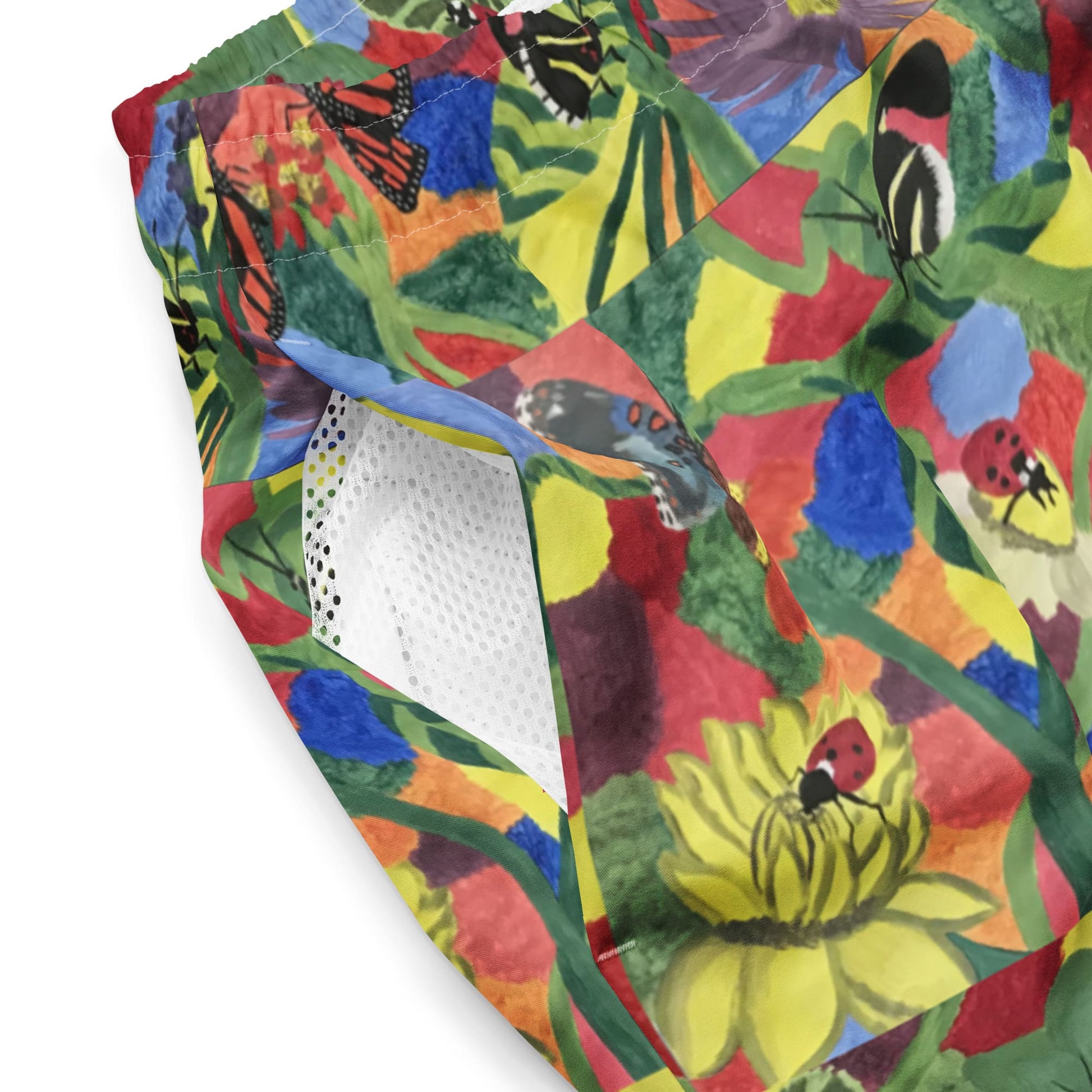 Close-up of mesh side pocket of men’s swim trunks with colorful floral insect print.