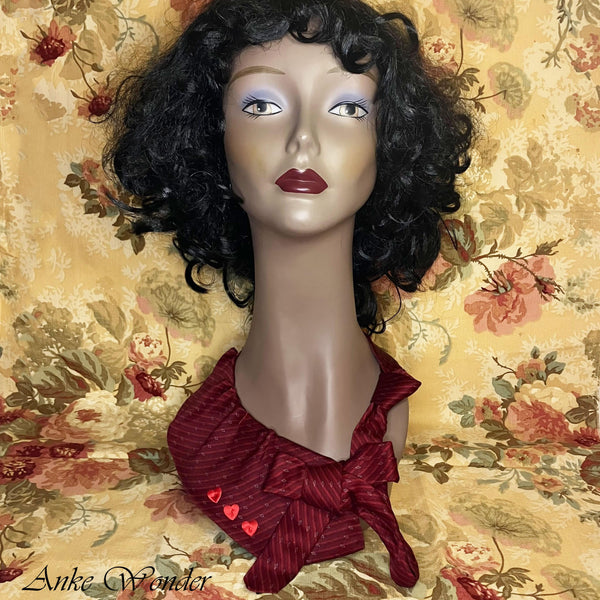 Front view of red womens necktie on a mannequin with a pleated bow and heart details.