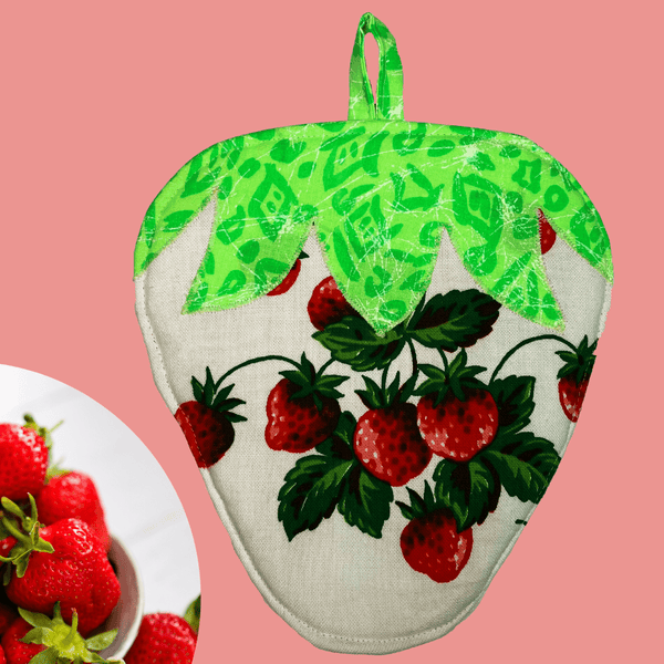 Back view of a handmade strawberry-shaped potholder, showing the vibrant red strawberry pattern on cream-colored cotton fabric with green leaves at the top.