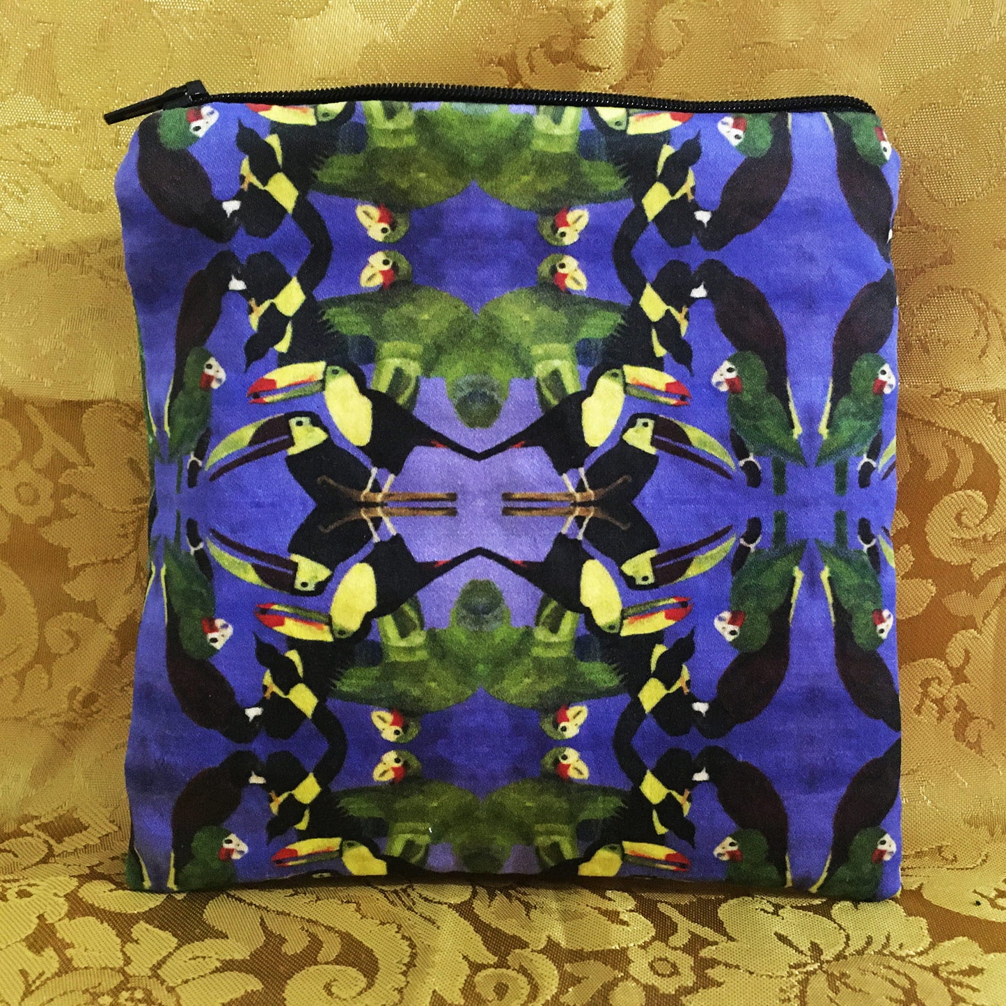 Pouch with toucan pattern on a gold background