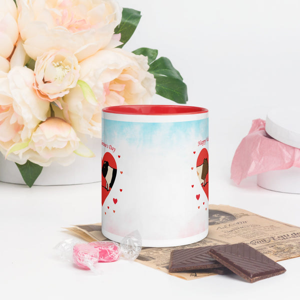 A partial side view of the ceramic mug, showing a soft watercolor-style background transitioning from blue to white. The red handle contrasts with the light background, adding a vibrant touch.