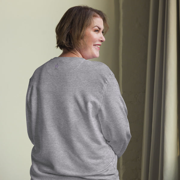 Back view of a woman wearing the green sweatshirt, highlighting the Anke Wonder label near the neckline, symbolizing sustainable craftsmanship.