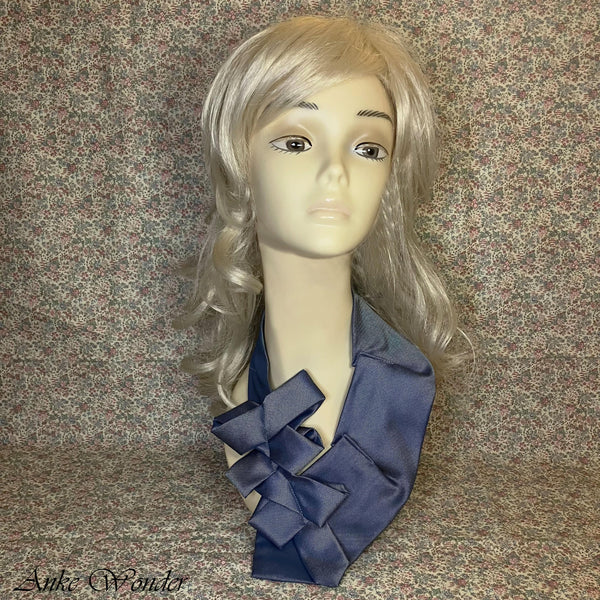 Full front view of a blue women's necktie displayed on a mannequin, featuring a bold bow-like layered design and a subtle sheen on the fabric.