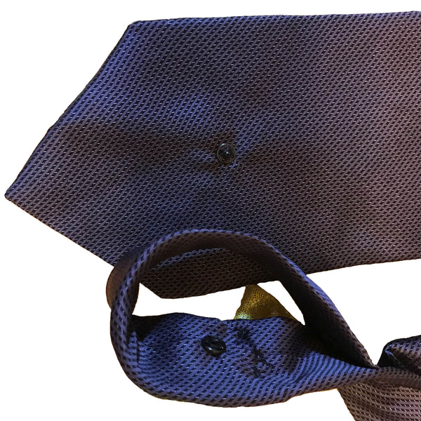 Closeup of the snap fastener on the back of the blue silk necktie, demonstrating easy wear.