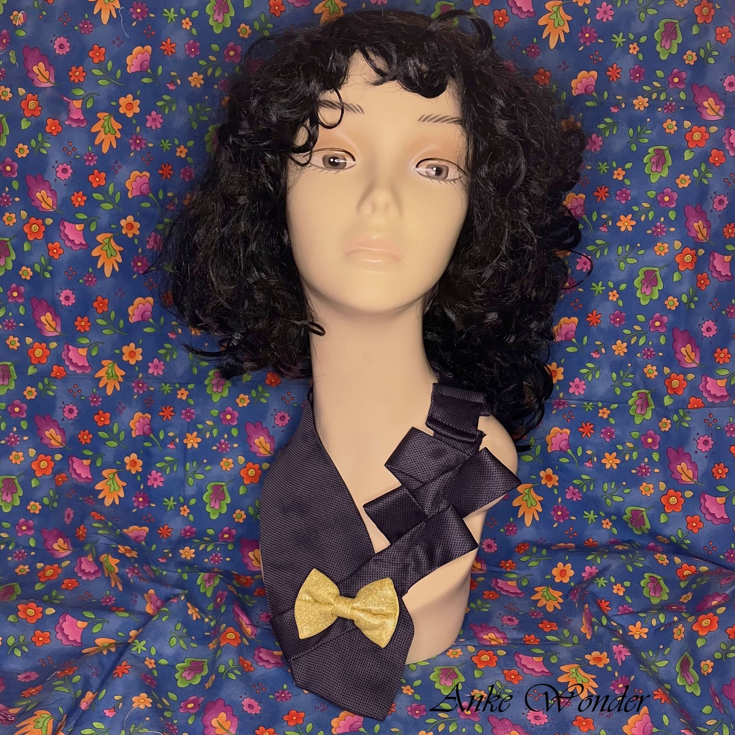 Handmade blue silk necktie with a yellow bow, displayed on a mannequin, featuring intricate pleated design and eco-friendly craftsmanship.