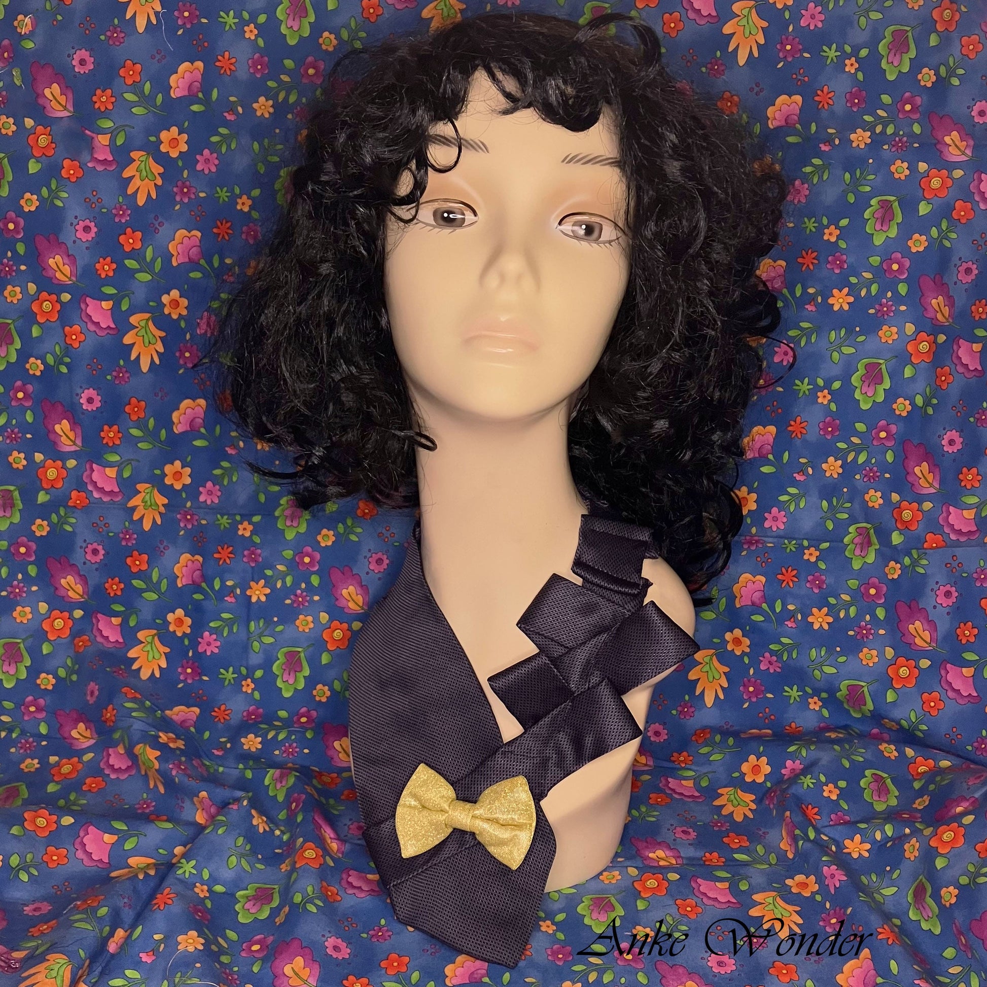 Handmade blue silk necktie with a yellow bow, displayed on a mannequin, featuring intricate pleated design and eco-friendly craftsmanship.