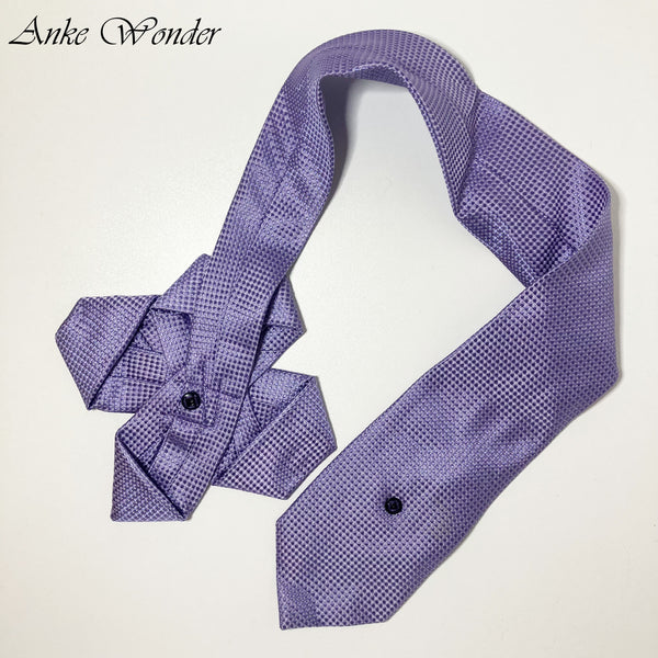 Handmade purple silk necktie with floral design, laid flat on a table showing the hidden snap fastener. Upcycled from a men’s tie.