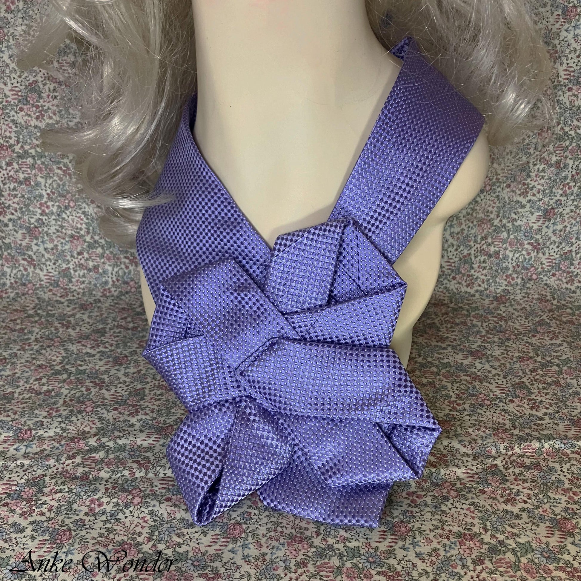 Close-up of Mannequin wearing a handmade purple silk necktie with a floral design, crafted from an upcycled men’s tie. Modeled by Anke Wonder.