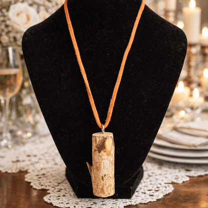 Necklace with a wooden pendant on a black bust in a festive setting