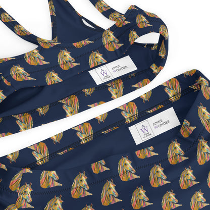 Close-up of a navy blue bikini top and matching bottoms with an all-over colorful horse pattern, laid flat on a white background. White brand labels reading 'ANKE Wonder' are visible inside bikini top and bottom.