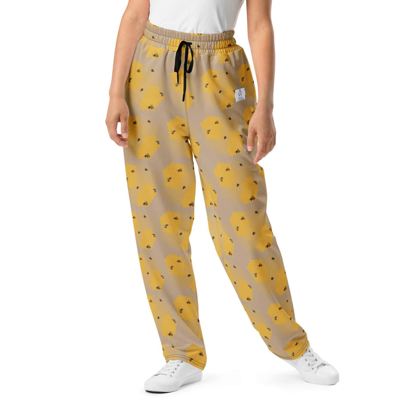 Close-up of handpainted bee design on women’s joggers in recycled fabric.